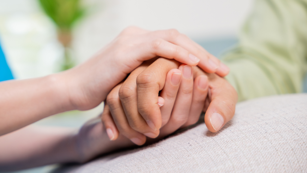 Zwei Hände halten sich einfühlsam – ein Symbol für Vertrauen, Unterstützung und Nähe in der häuslichen Pflege. Das Bild bringt die menschliche Seite der Betreuung zum Ausdruck und unterstreicht, wie wichtig zwischenmenschliche Verbundenheit im Pflegealltag ist. Die IAHA (International Association for Healthy Aging) engagiert sich für ganzheitliche Ansätze, die emotionale Fürsorge und körperliches Wohlbefinden im Rahmen der häuslichen Pflege stärken.